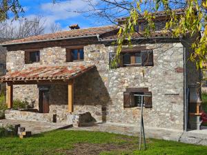 a stone house with a cat sitting on top of it at Can Tadeu in Camprodon
