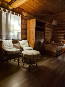 a room with a bed and a table in a room at Wilcza Jama - domki, sauna in Lutowiska