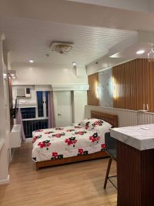 a bedroom with a bed with red flowers on it at Tagaytay Prime Residence City Land in Tagaytay