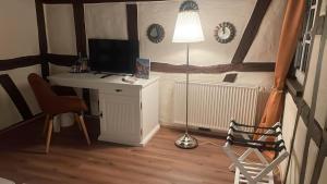 a room with a desk with a lamp and a computer at Hotel Restaurant Altes Badhaus in Eberbach
