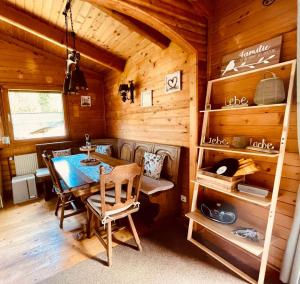 a dining room with a table in a wooden cabin at Glücksfleckerl in Nagel