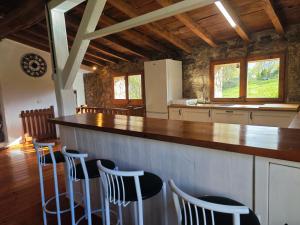 a kitchen with a counter and stools in a room at Can Tadeu in Camprodon