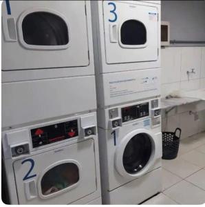 three washing machines are stacked next to each other in a kitchen at Kit 102 Brasília in Brasilia +8 photos