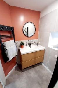 ein Badezimmer mit Waschbecken und Spiegel in der Unterkunft Evasion vintage in La Sauvetat + 12 Fotos