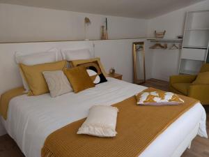 ein Schlafzimmer mit einem großen weißen Bett und einer Couch in der Unterkunft Evasion vintage in La Sauvetat