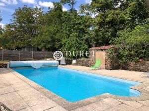 a blue swimming pool with a sign that reads divorce at Gîte de la Rochejaquelein in Saint-Fulgent