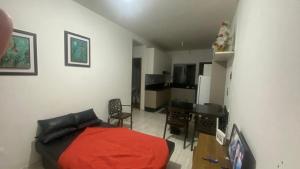 a bedroom with a bed and a table and a kitchen at Casa região central Guaratuba in Guaratuba