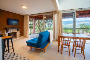a dining room with a table and a blue chair at Refúgio Sagaz no Vale do Capão in Palmeiras