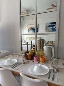 a kitchen counter with two white plates and a mirror at JK Suites Cheer B126 in Marilao +11 photos