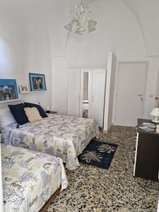 una camera da letto con due letti e un tavolo di Pietra su Pietra Casa Vacanze ad Alezio Altre 35 foto