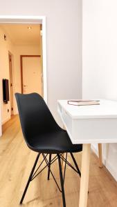 a black chair sitting next to a white desk at Le Cocon Studio in Brussels
