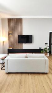 a white living room with two white couches at Le Cocon Studio in Brussels