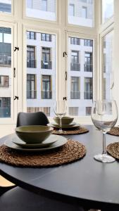 a table with plates and glasses on a table with windows at Le Cocon Studio in Brussels