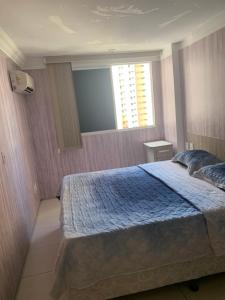una camera da letto con un letto grande e una finestra di Apartamento lindo e perto da praia a Fortaleza