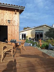 a patio with a table and chairs on a wooden deck at Lodge les ombelles in Coutras