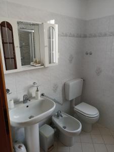 a white bathroom with a sink and a toilet at Isangarda Apartment in Candelo +14 photos