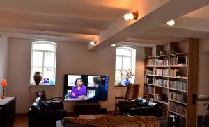 a living room with a tv and a book shelf at Col du Fatten in Beek