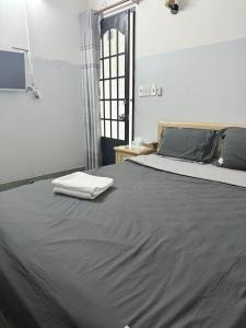 a bedroom with a large bed with a gray blanket at Nhà Nghỉ Thanh Thủy in Xã Phước Lễ