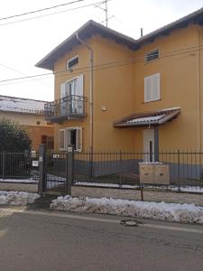 a yellow house with a fence in front of it at Isangarda Apartment in Candelo