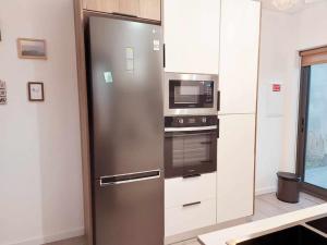 a kitchen with a stainless steel refrigerator and microwave at Salmoura's Place AL 4724 in Santa Cruz das Flores