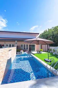 una piscina davanti a una casa di D' Village Cottage 2 - Private Pool Villa a Pantai Cenang