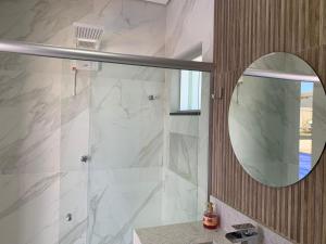 ein Badezimmer mit Dusche mit Spiegel und Waschbecken in der Unterkunft Recanto do Guerreiro in Brasilia