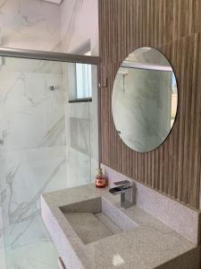 ein Badezimmer mit Dusche, Waschbecken und Spiegel in der Unterkunft Recanto do Guerreiro in Brasilia