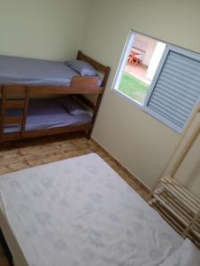 a room with a bed and a window and a rug at Green Home in Águas de Santa Barbara