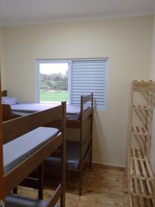 a room with three bunk beds and a window at Green Home in Águas de Santa Barbara