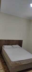 a bed in a room with a white mattress at Green Home in Águas de Santa Barbara