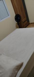 a bedroom with a white bed with a window and a door at Green Home in Águas de Santa Barbara