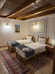 Un dormitorio con dos camas y una alfombra. en Mehrob Hotel Bukhara, en Bukhara