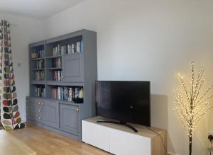 a living room with a tv and a book shelf at Blaengwen Bach in Pencader