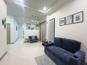 a living room with a blue couch and a hallway at DelZiaNa Bara Villa Pakbara Satun พักได้ 6 ท่าน in Ban Pak Ba Ra
