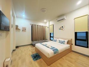 a bedroom with a bed and a flat screen tv at DelZiaNa Bara Villa Pakbara Satun พักได้ 6 ท่าน in Satun