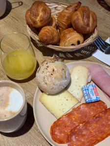 a table with a plate of cheese and pastries and bread at Hôtel Breizh Du Golfe in Arzon +27 photos