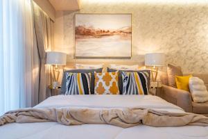 a bedroom with a large bed with colorful pillows at Ivory Residences I Premium Apartment l Close to Malls I Downtown I Managed by Bleuspace in Davao City