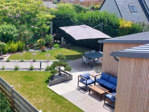 un patio con una mesa y una sombrilla en Île Grande, Location maison saisonnière chez Dom et Cathy C, en Pleumeur-Bodou
