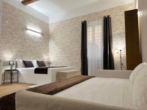 a bedroom with two beds and a brick wall at No Name Prestige Apartment in Bologna