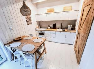 a small kitchen with a wooden table and chairs at Stodółka Białogóra in Białogóra +8 photos