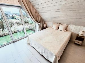 a bedroom with a bed and a large window at Stodółka Białogóra in Białogóra