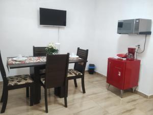 a dining room with a table and chairs and a tv at Flat Sr Marinheiro in São Miguel do Gostoso