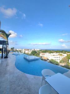 a large swimming pool with a view of a city at Tu estancia perfecta - ubicación y privacidad in Playa del Carmen
