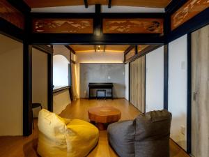 a living room with a couch and a table at ゲストハウスはれのち in Furunoushigawa