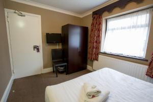a bedroom with a bed and a television at Banks Hotel in Ilford