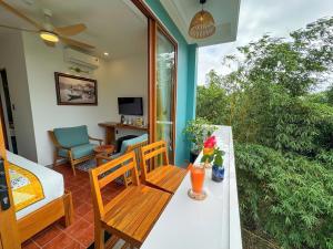 a room with a table and chairs and a living room at Blue Tropical House Hội An in Hoi An
