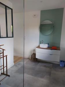un baño con lavabo y espejo en Île Grande, Location maison saisonnière chez Dom et Cathy C, en Pleumeur-Bodou