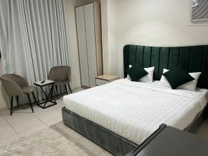 a bedroom with a large bed with a green headboard at وحدات سكنية مفروشة in Jeddah