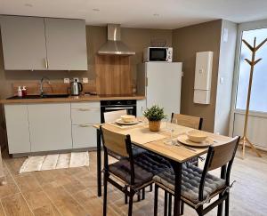 a kitchen with a table and chairs and a refrigerator at Appartement Sainte-Catherine in Sainte-Catherine-sur-Riverie