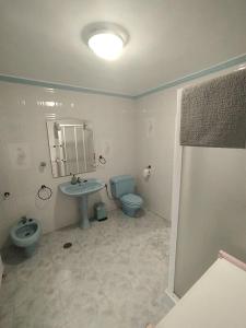 Un baño con lavabo, inodoro y espejo. en Casa Karto, en Ronda 15 fotos más
